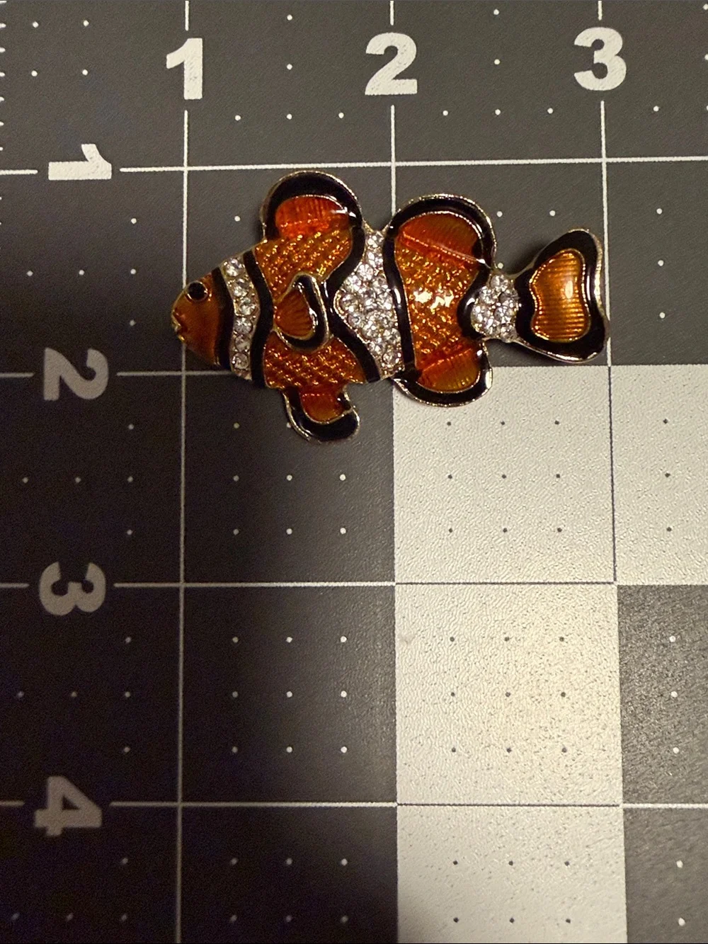 clownfish brooch featuring vibrant orange and black enamel